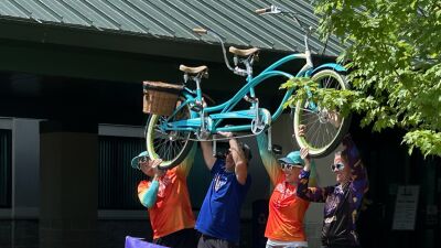  Participants hold up a tandem bike after completing a past Ride 2 End Suicide bicycle ride. 