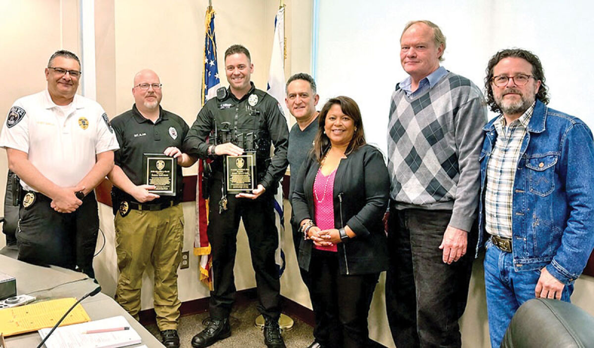  Flanked by Keego Harbor Police Chief Robert Barnes, council members and Mayor Joel Ross, Det. Kevin Oliver, second left, and officer James Dennis were recently honored for their heroism during the Temple Israel attack with a “Valor Award.” 