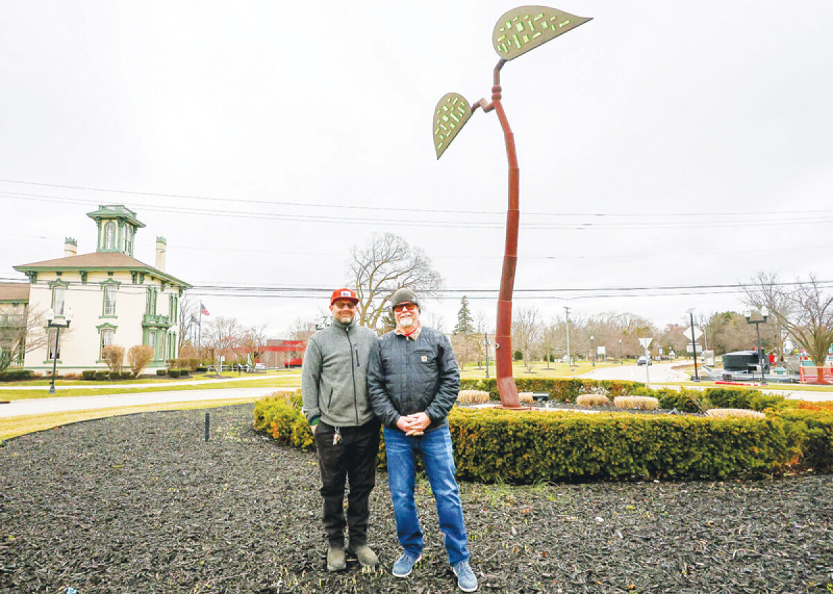 Israel and Erik Nordin stand by “The Seed,” their public art sculpture located within the traffic circle at Utica Road and Dodge Park Road. The brothers were raised in Sterling Heights and are working on their fifth commission for the city. 