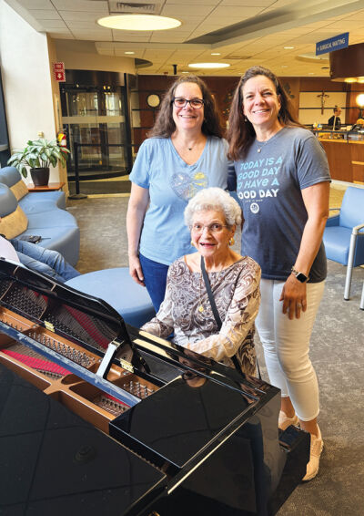  When celebrating their 56th birthdays April 17, Aileen Thorington, left, and Ann Lundy visited with their mother Sara Scrivano, at the piano, at Henry Ford Warren Hospital. It’s where the twin sisters were born in 1970.  