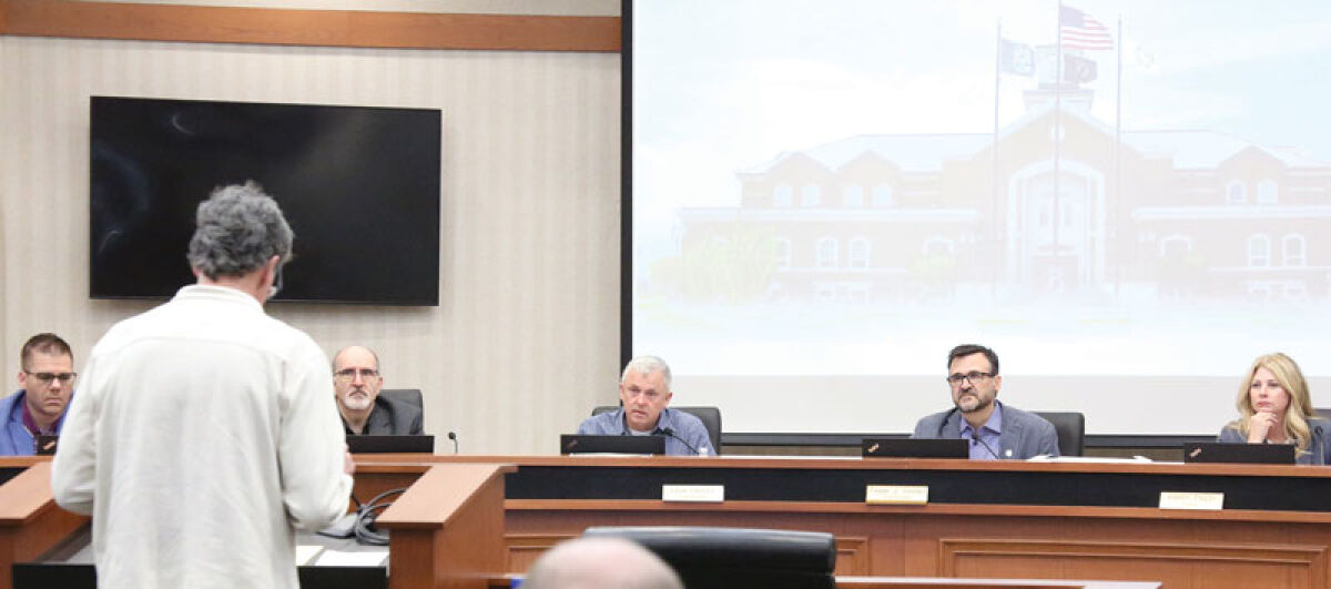  The Macomb Township Board of Trustees listens to a resident speak about sidewalk repairs at the board’s April 22 meeting. 