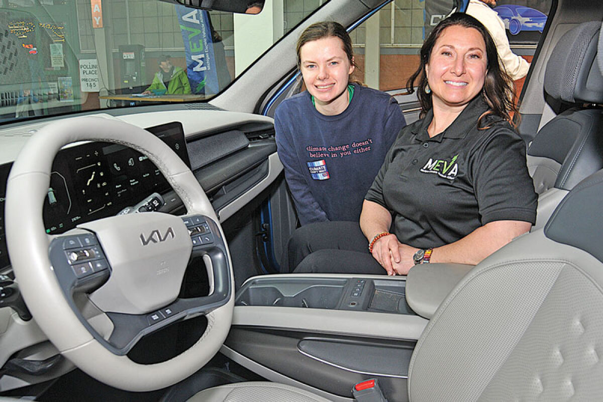  Amy Rogghe, right, founder of Michigan Electric Vehicle Alliance, offered test drives in her personal electric car. Joining her is Earth Day volunteer Erin-Grace Walden. 