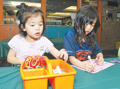  Joanna Yoon, 4, and her sister Elizabeth, 7, used the available materials to create their cards.  