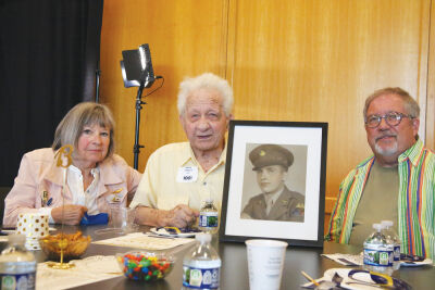 Marvin Porretta, 102, poses for a photo at a May 8 100 Club celebration alongside son Michael, daughter Diane Fox and a photo of himself in the Army. Originally from Ohio, Marvin’s lifetime hobbies include SCUBA diving, camping, skating, biking, bingo and watching movies. 