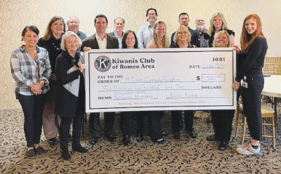   The Four County Community Foundation Friends of Imagination Library, represented by Kathie Proctor and Julie Shanks, third and fourth from the right in the front row, receives a $4,500 check from the Kiwanis  Club of Romeo Area. 