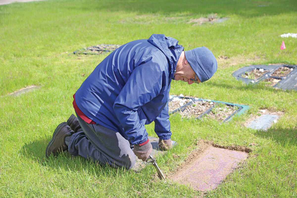  John Rash, a Royal Oak resident, cleans up a veteran’s gravesite at Oakview Cemetery May 2. 