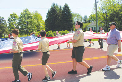 Boy Scout Troop 125 carries a flag down Adams Road during a past parade. 