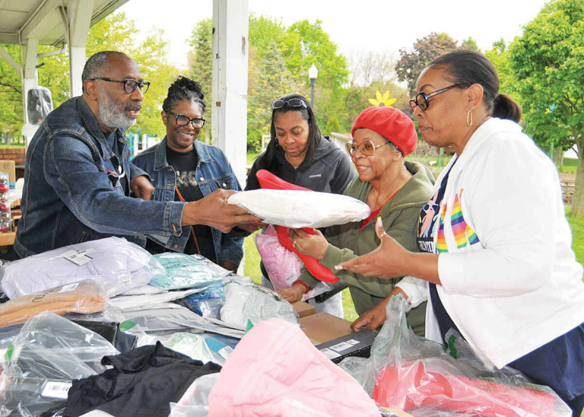  Logos Church Pastor Scottie L. Jones, left, and his wife Charlotte, standing next to him, help Lathrup Village residents pick out items offered free to the community on May 16. Logos Church and the Lathrup Village Downtown Development Authority co-sponsored a community event at Lathrup Village City Hall as part of the nationwide Good Neighbor Day America. 