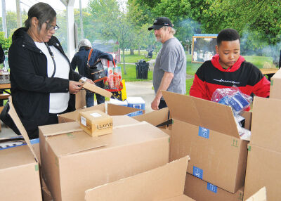  People look through Amazon boxes filled with surplus goods available at no cost to anyone attending the event. 