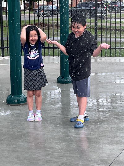  Ariel Kue, 7, and Princeton Kue, 9, wait for the dump bucket at the splash pad ribbon cutting May 19 in Roseville. 