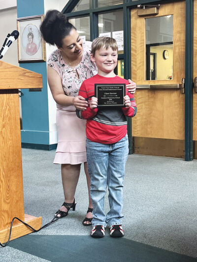  Crothers Elementary third grade student Liam Garriott poses for photos while teacher Selvana Sharaby congratulates him.  