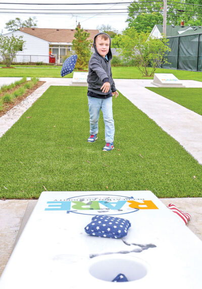 Four-year-old Zeke Bowman, of Roseville, tries out the cornhole court.