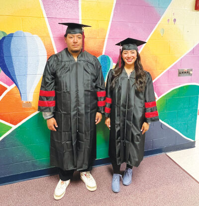  Mother and son Natalie Paramo and Juliun Lopez try on their caps and gowns as they prepare to graduate together this Saturday at Oakland University Credit Union O’Rena. Paramo will be receiving her high school diploma from the Utica Community Schools Adult Education program, and Lopez will be receiving his high school diploma from the Utica Alternative Learning Center.  
