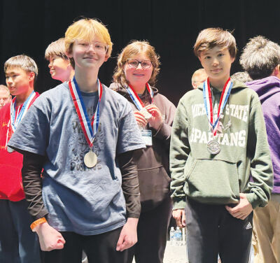  From left, Sam Coots, Joanna December and Bryce Leddington received second place  in the Codebuster Division during the 2026 Michigan Science Olympiad State Tournament at Michigan State University. 