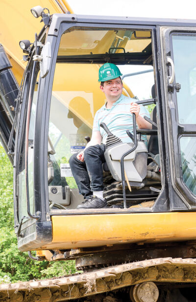  Jeffrey Brake, a future resident of Auburn Oaks, operates the machinery with some assistance to break the ground of the Auburn Oaks community. 