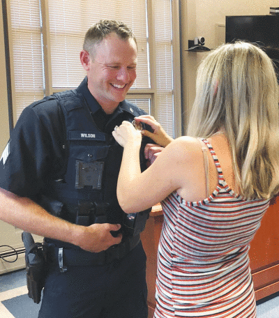  Grosse Pointe Shores Public Safety Sgt. Ryan Wilson’s wife, Caroline, pins his new badge on his uniform after he’s sworn in. 