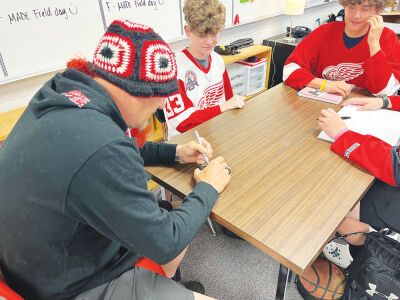 Detroit Red Wings hockey legend Darren McCarty signs autographs after seeing students Jacob Cox, Johnathan Konwerski and Austin Simpson give a presentation on the Red Wings game against the Colorado Avalanche, billed as “Fight Night at the Joe.” 