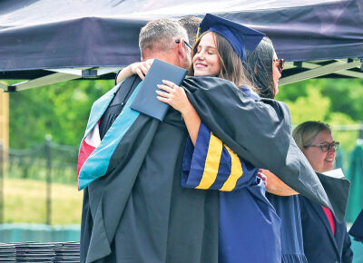 Principal Ryan Sines hugs his daughter Francesca Sines.