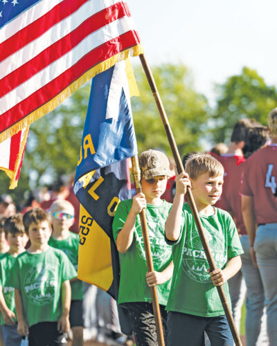  Scouts bring in the American flag during the presentation of the colors at the Royal Oak Lephrechauns game May 29. 