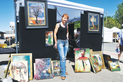 Artist Mari Pruks stands among her paintings at the Berkley Art Bash.