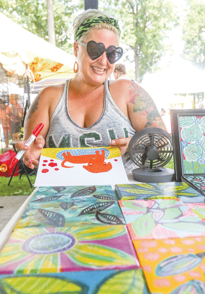  In this file photo from last year’s Hazel Park Arts Fair, mixed-media artist Sarah Jean Anderson works on one of her whimsical pieces. This year’s event is set to take place at Green Acres Park Aug. 27-28. 