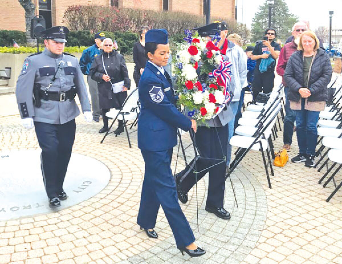  As part of its traditional salute outside of City Hall, the city of Troy arranged for a rifle salute, music from the Heritage Concert Band of Troy and a memorial wreath, pictured. 
