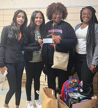  Lead volunteers at HSS Deeksha Hadagali and Shrusti Basarkod, left and far left, present a check to Kathy Roberts and Dr. Natoya Coleman, right and far right, of Doyle-Ryder Elementary School. 