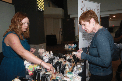  Jessica Black, left, a Clarkston native, showcases her all-natural soaps as Farmington Hills native Rochelle Freeman observes the product. 