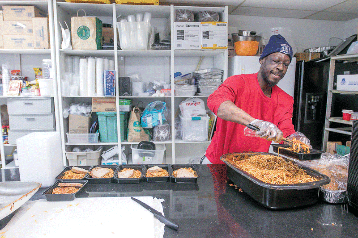  Tamir Newton, a Motor City Mitten Mission chef, plates the day’s meals Nov. 30. Newton cooks and prepares meals for 100 to 150 people a day.  