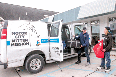  Gregory Gaynor, left, and Kalem Catom load up the Motor City Mission outreach van with food to distribute  to the homeless.  