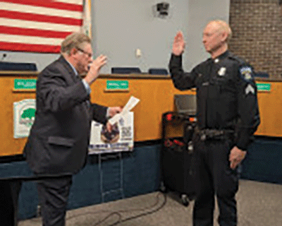  Shelby Township Clerk Stan Grot gives the oath of office to Ted DeMeritt as he is promoted to police sergeant last month. 