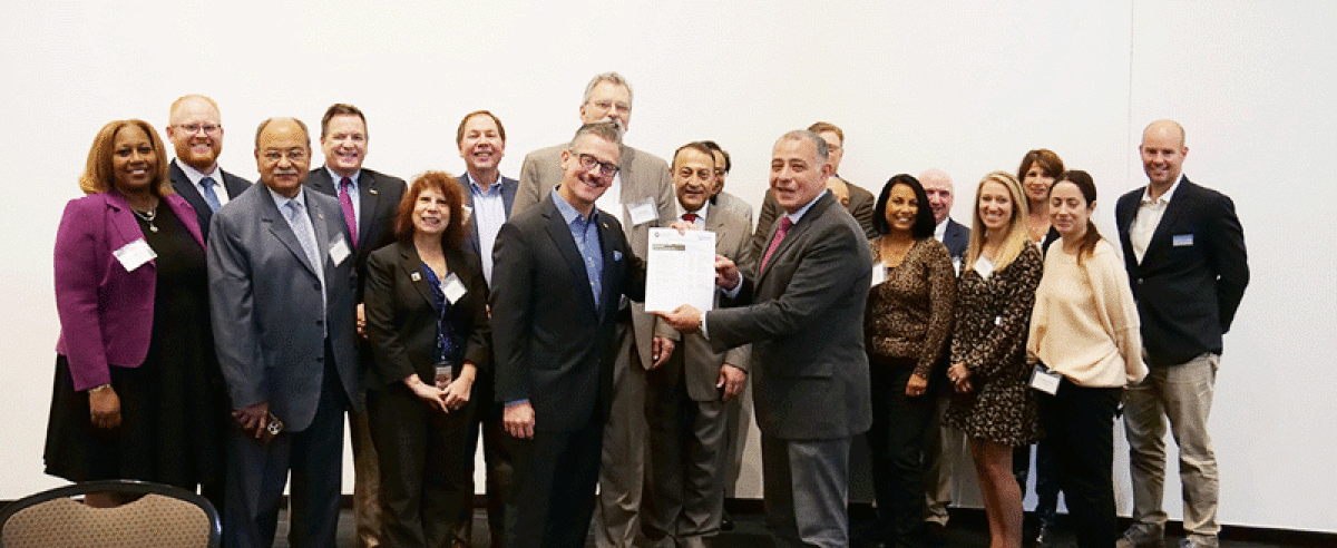  Oakland Community College Chancellor Peter Provenzano Jr., left, and LTU President Tarek M. Sobh, right, pose with the pre-engineering articulation agreement surrounded by OCC professors and administrators.  