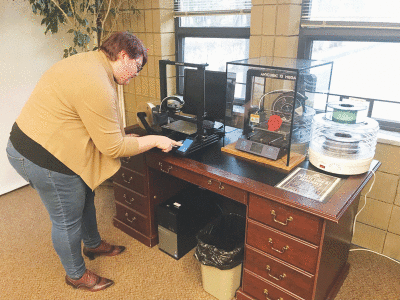  Kristen Getzin, the programming and youth services librarian at the Fraser Public Library, sets up the library’s 3D printer. It is one of the technology-related resources they hope to grow with a bond proposal up for a vote by the Fraser City Council. 
