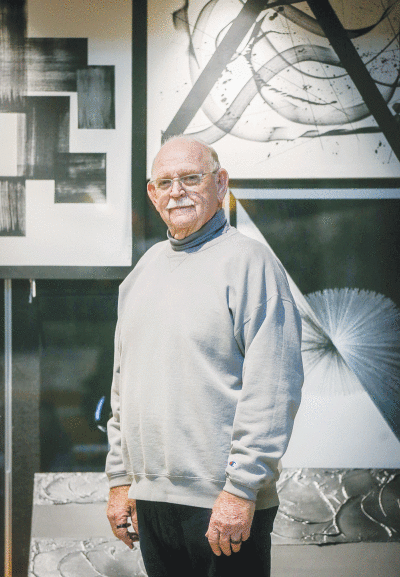  Sterling Heights Featured Artist Frank Blowers stands near his showcased abstract artwork. The city of Sterling Heights plans to showcase Blowers’ work throughout December and January at the upper level of the Sterling Heights Community Center. 