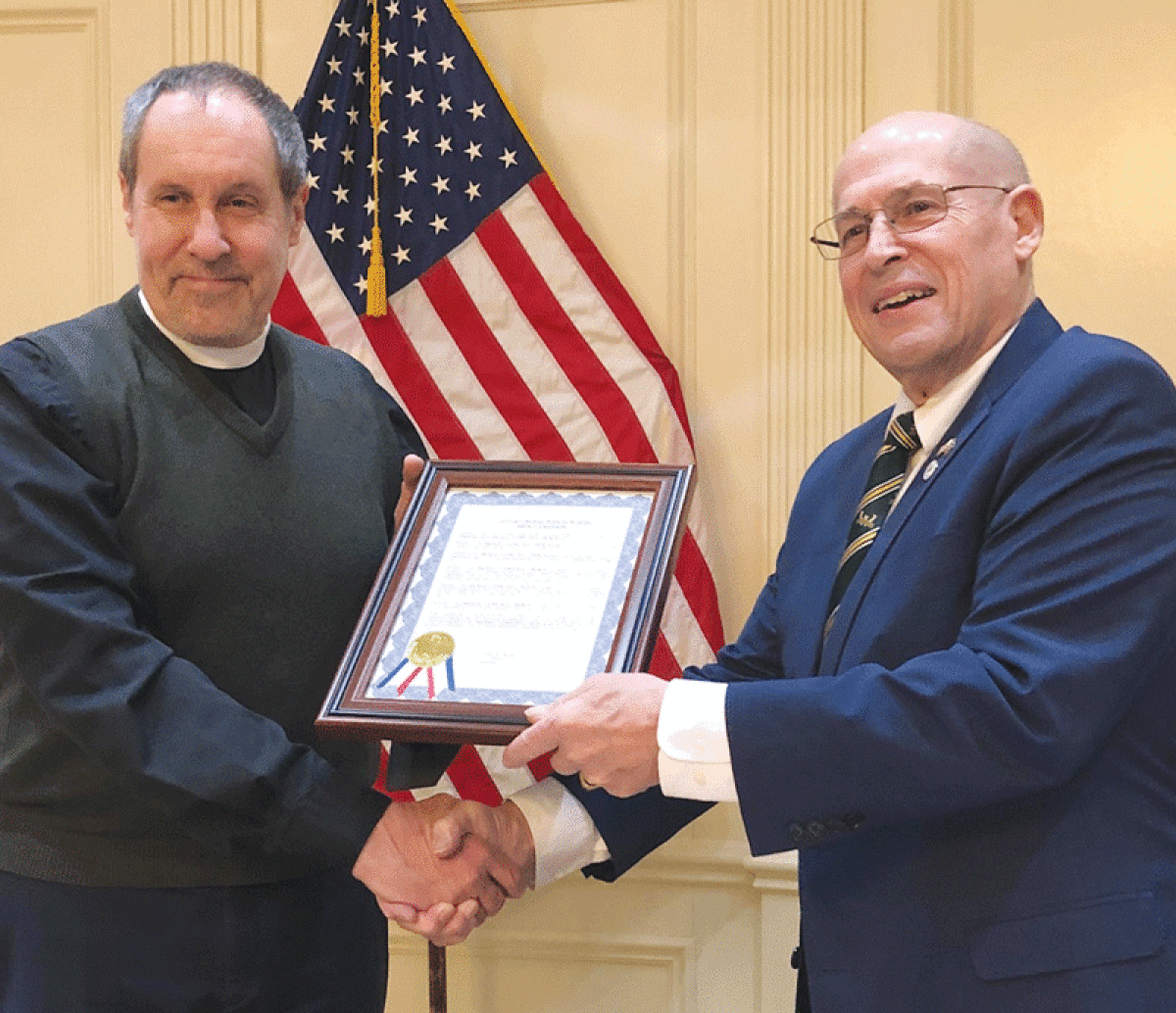  The Rev. Michael Bradley, of St. Michael’s Episcopal Church in Grosse Pointe Woods, holds a proclamation presented by Woods Mayor Arthur Bryant, pictured, and other city leaders Dec. 5 to commemorate the church’s 75th anniversary. 
