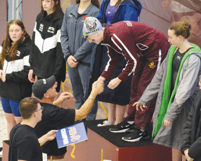  Junior Kelley Hassett accepts her first-place MHSAA championship in the 500-yard freestyle. 