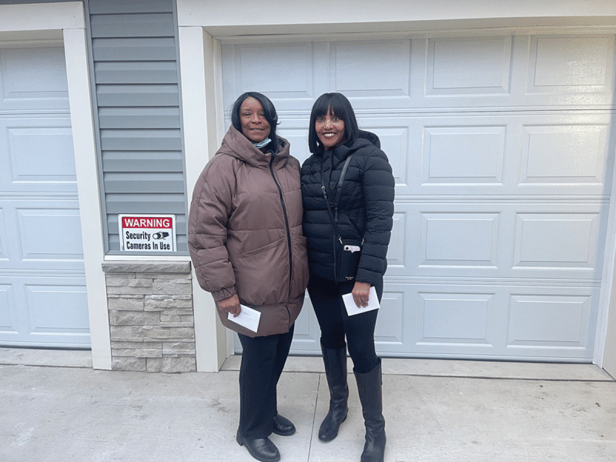   New homeowners Alice Harris and Loria Logan pose outside  of the finished duplex in Southfield Dec. 6.  
