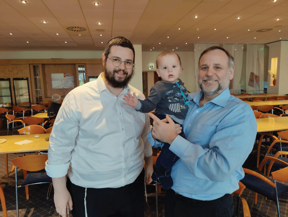  Ethan Gross, during his visit to the Mishpacha Orphanage of Odesa, poses with Rabbi Mende Wolff, left, and 9-month-old Tuvia. 