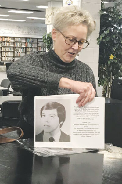  Kathy Loftus presents to school officials the hardcover book that honors her brother and the scholarship program in his name. 