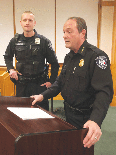  The meritorious conduct award that Harper Woods bestowed on Grosse Pointe Park Public Safety Department officer Brady Baetens, left, is explained by Park Public Safety Director Bryan Jarrell during a Nov. 28 Park City Council meeting. 