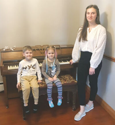  Elvira Rohovets and her children, Lev, age 5, and Maia, age 3, welcome their new piano into their home, gifted to them from The Piano Place in Troy after having to leave their home in war-torn Ukraine. 