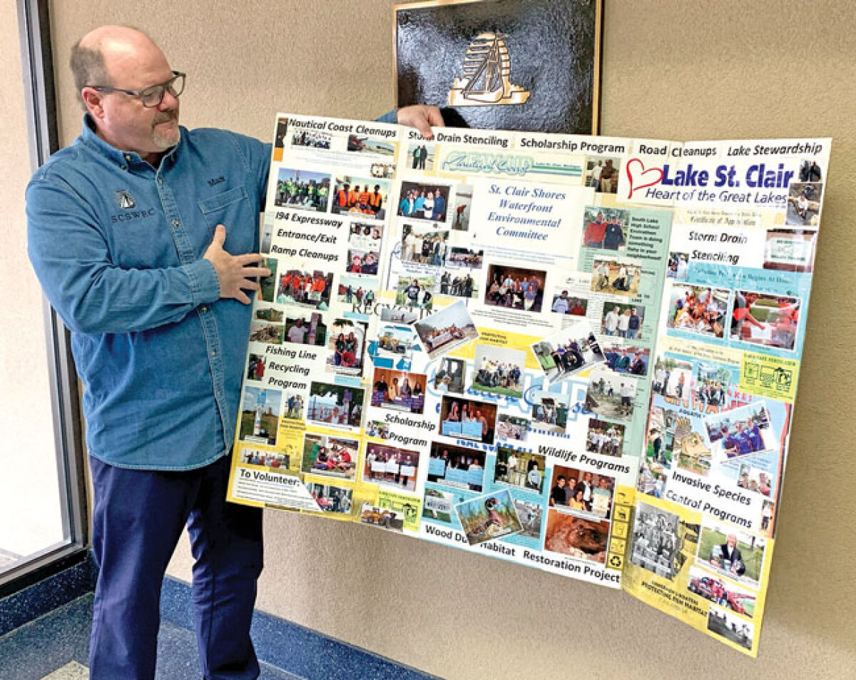  Mark Balon shows a poster filled with information about the St. Clair Shores Waterfront Environmental Committee at the St. Clair Shores City Hall. 