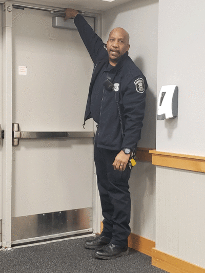  Farmington Hills Police Detective and School Resource Officer Kevin Clark points out the door hinges on the side door during a community dialogue session at the Maxfield Education Center Jan. 26. A sleeve can be placed over the hinge to prevent the door from opening in the event of a threat. Classrooms have been equipped with these sleeves, which teachers and taller students can place in the event of an emergency.   