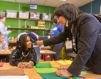  United Way Director of K-12 Education Initiatives Pamela Todd poses with a student after making tissue flowers. 