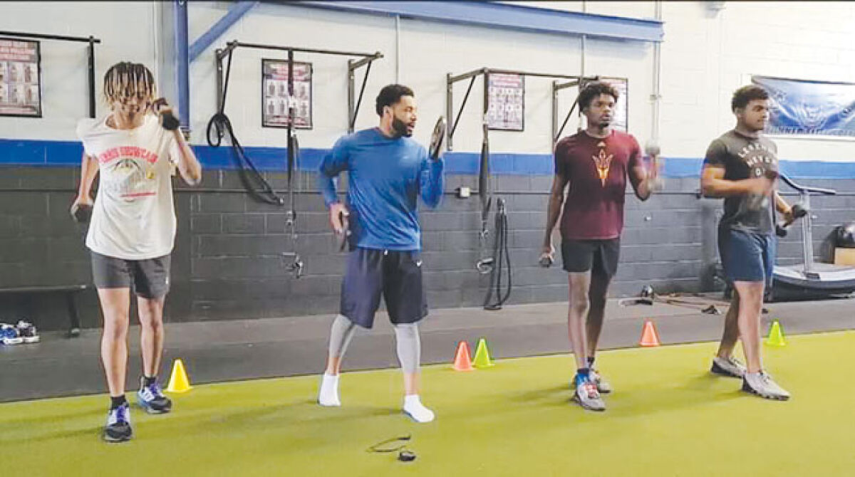  Johnie Drake works with three of his athletes during a strength and motion exercise. 