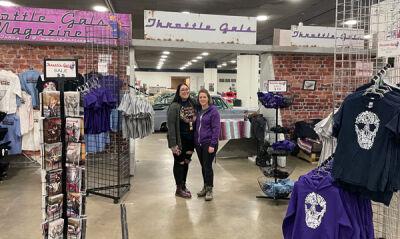  Trish Horstman and Doni Muzzi in front of the Throttle Gals booth at Detroit Autorama 2022. 