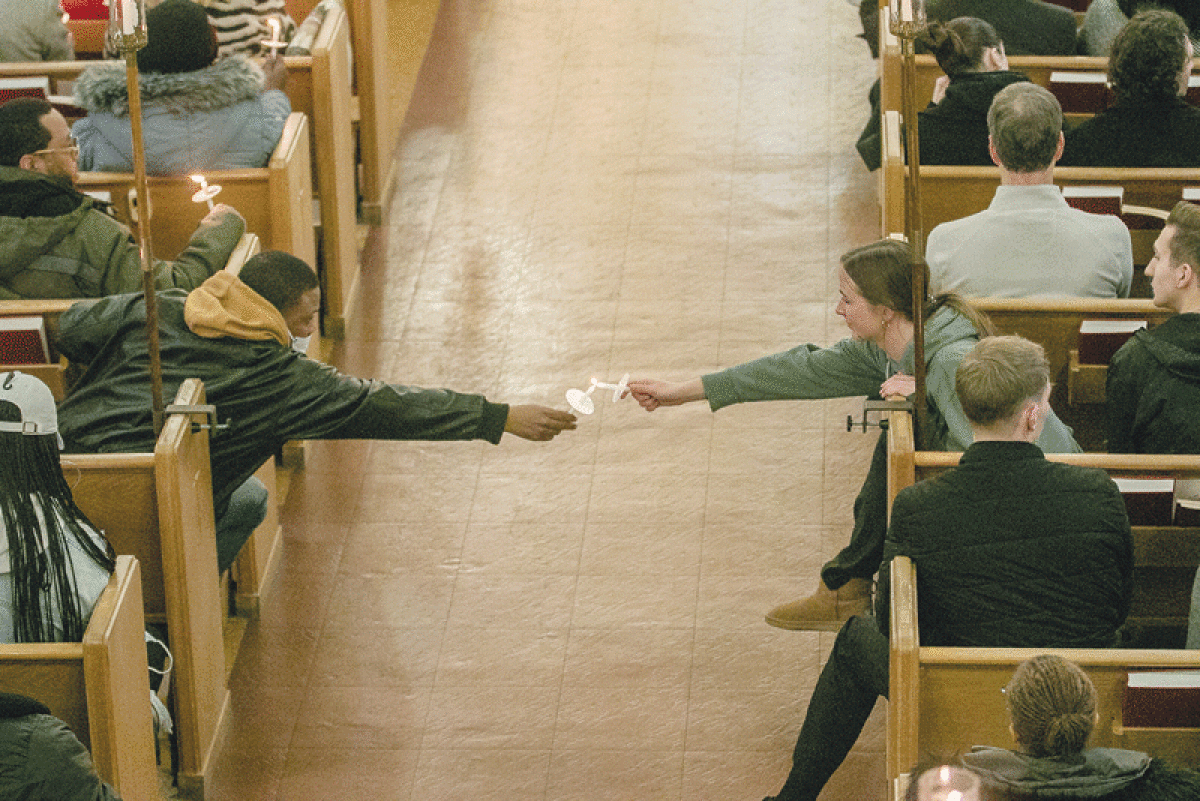  Mourners light each other’s candles during a Feb. 18 vigil at First English Evangelical Lutheran Church in Grosse Pointe Woods for Arielle Anderson. 