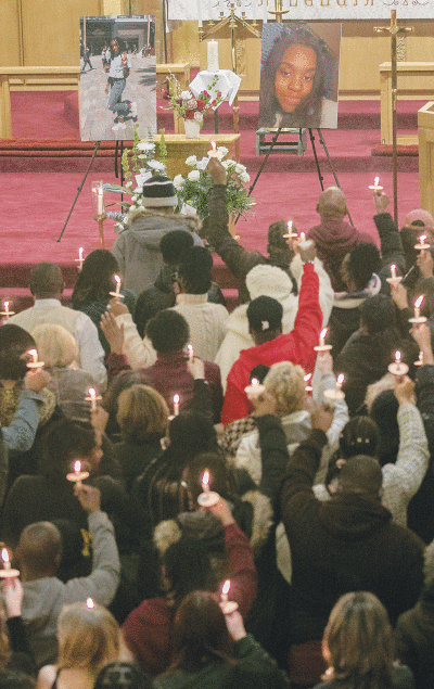  Mourners hold candles aloft for Arielle Anderson as  they honor her memory and pray for her family during a service Feb. 18 at First English Evangelical Lutheran  Church in Grosse Pointe Woods. 