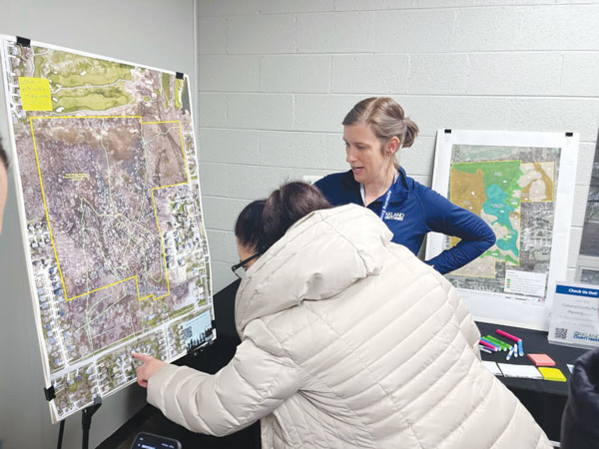  Jess Whatley, an associate planner with the Oakland County Parks and Recreation Department, shows Troy residents plans for Turtle Woods, a parcel of land they are in the process of purchasing from the Troy School District for use as a nature preserve. 
