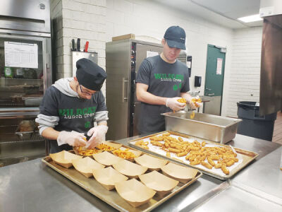  Hunter Goodman and Matt Heslop prepare french fries and cheese sticks for the Novi High School cafeteria. 